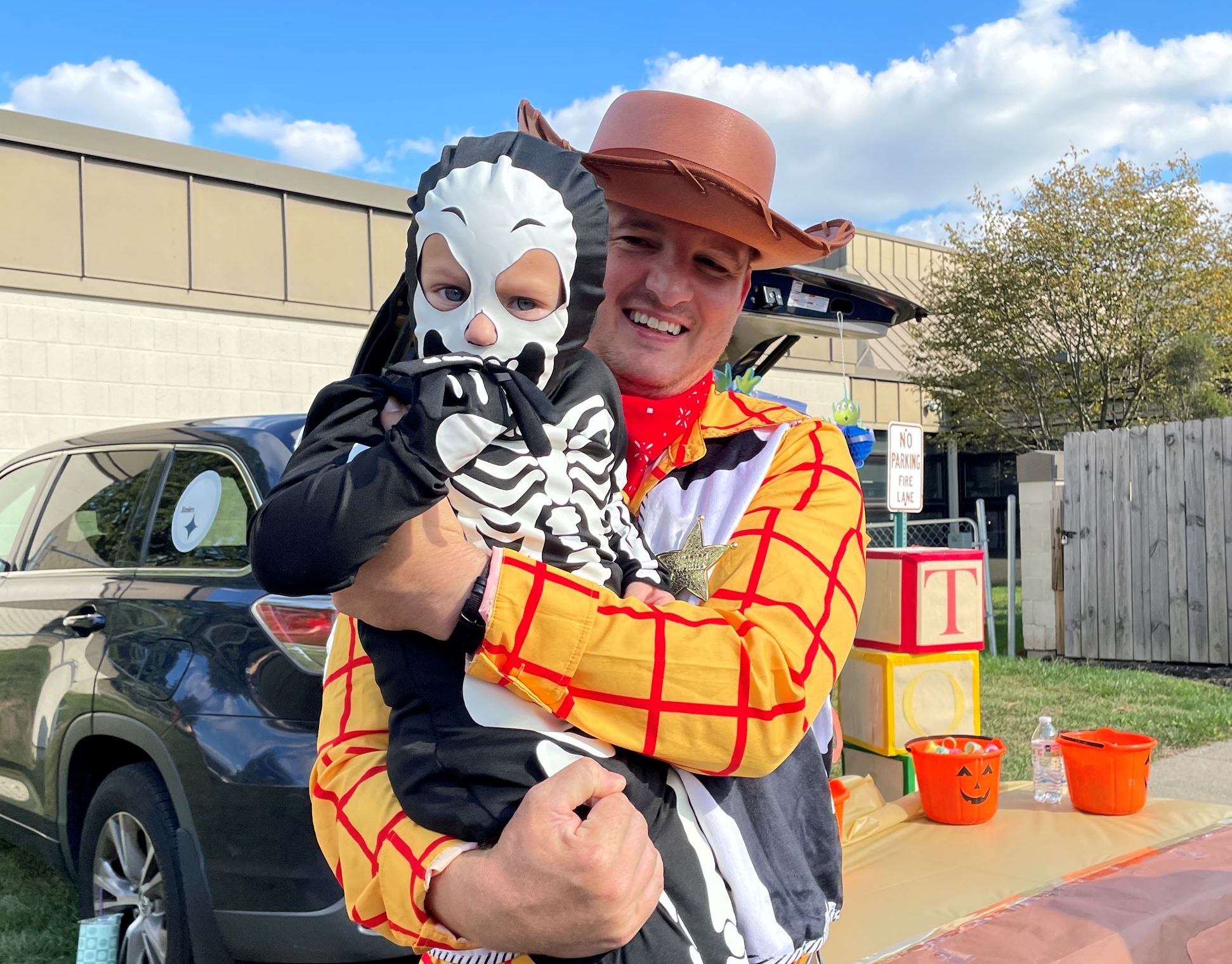 Woody from Toy Story poses with a little skeleton.